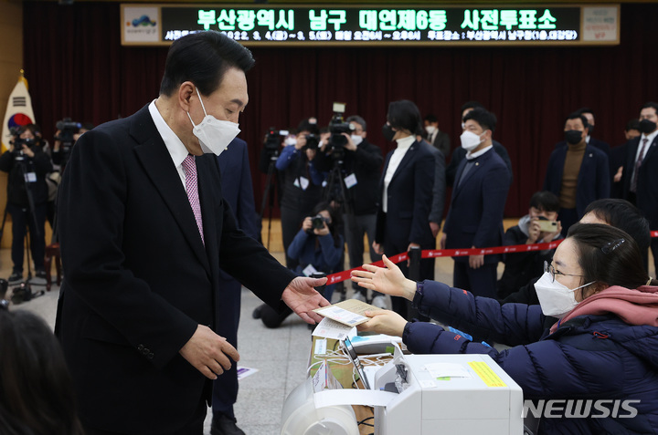 [부산=뉴시스] 전신 기자 = 윤석열 국민의힘 대선 후보가 4일 부산 대연동 남구청에 마련된 사전투표소에서 투표 용지를 받고 있다. 2022.03.04. photo1006@newsis.com