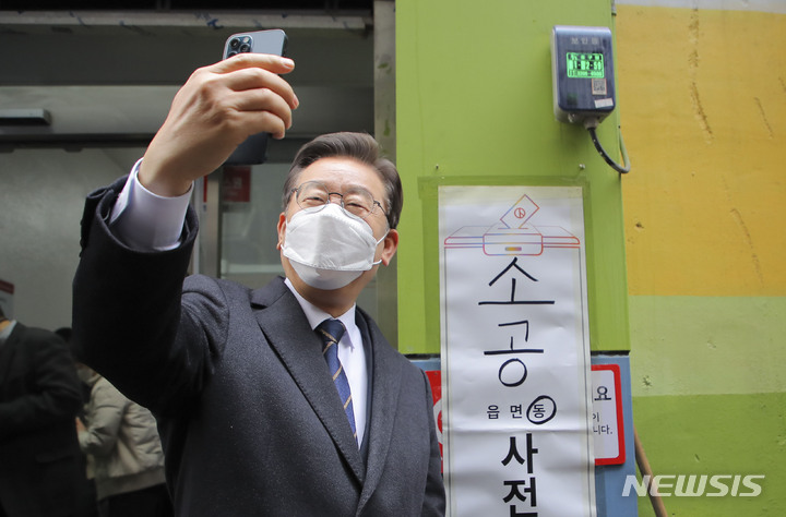 [서울=뉴시스] 국회사진기자단 = 이재명 더불어민주당 대선 후보가 4일 오전 서울 중구 소공동 주민센터에 설치된 사전투표소에서 투표를 마친 후 인증샷을 찍고 있다. 2022.03.04. photo@newsis.com