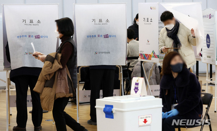 [인천공항=뉴시스] 홍효식 기자 = 제20대 대통령선거 사전투표 첫 날인 4일 인천국제공항 제1터미널 출국장 G 체크인 카운터에 마련된 사전투표소에서 유권자들이 투표를 하고 있다. 2022.03.04. yesphoto@newsis.com