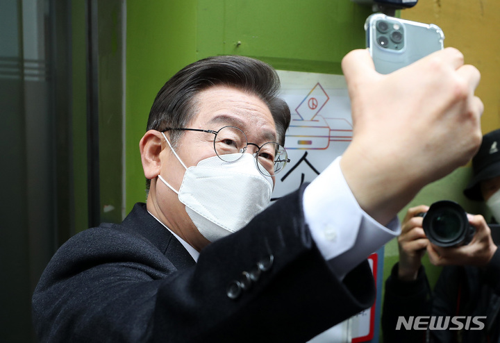 [서울=뉴시스] 국회사진기자단 = 이재명 더불어민주당 대선후보가 4일 오전 서울 중구 소공동 주민센터에서 사전투표를 마친 뒤 인증샷을 남기고 있다. 2022.03.04. photo@newsis.com