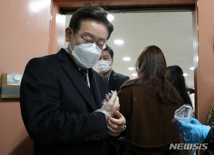 [서울=뉴시스] 국회사진기자단 = 이재명 더불어민주당 대선후보가 4일 오전 서울 중구 소공동 주민센터에 마련된 사전투표소에서 투표에 앞서 손소독과 위생장갑을 착용하고 있다. 2022.03.04. photo@newsis.com
