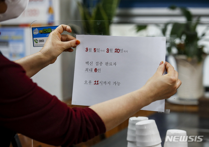 [서울=뉴시스] 정병혁 기자 = 정부가 사회적 거리두기를 일부 완화한 4일 오전 서울시내 한 식당에서 관계자가 새로운 거리두기 안내문을 붙이고 있다. 오는 5일부터 20일까지 완화된 방역체계에 따라 식당과 카페 등 다중이용시설은 오후 11시까지 영업이 가능하다. 2022.03.04. jhope@newsis.com