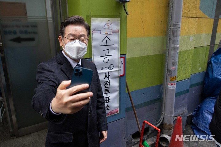 [서울=뉴시스] 국회사진기자단 = 이재명 더불어민주당 대선 후보가 4일 오전 서울 중구 소공동 주민센터에 설치된 사전투표소에서 투표를 마친 후 투표 인증 사진촬영을 하고 있다. 2022.03.04. photo@newsis.com