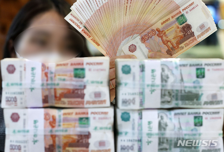 [서울=뉴시스] 홍효식 기자 = 러시아의 신용등급 강등에 따라 루블화 가치가 사상 최저로 떨어졌다. 현지시간 어제(3일) 오전 모스크바 외환거래소에서 루블화 환율은 달러당 117.5루블, 유로당 124.1루블까지 올랐다. 달러당 110루블을 넘긴 것은 이번이 처음이다. 4일 서울 중구 하나은행 위변조대응센터에서 직원이 루블을 보여주고 있다. 2022.03.04. yesphoto@newsis.com