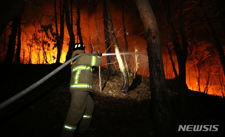 [울진=뉴시스] 이무열 기자 = 4일 경북 울진군 북면 두천리에서 일어난 산불이 강풍을 타고 민가까지 불이 번져 소방관이 진화 작업을 벌이고 있다. 2022.03.04. lmy@newsis.com