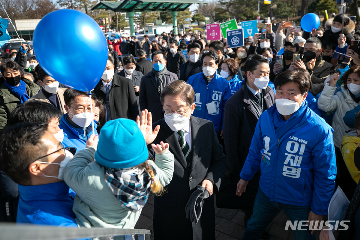 [오산=뉴시스] 국회사진기자단 = 이재명 더불어민주당 대선 후보가 5일 경기 오산시청 앞에서 유세를 열고 한 아이와 인사하고 있다. 2022.03.05. photo@newsis.com