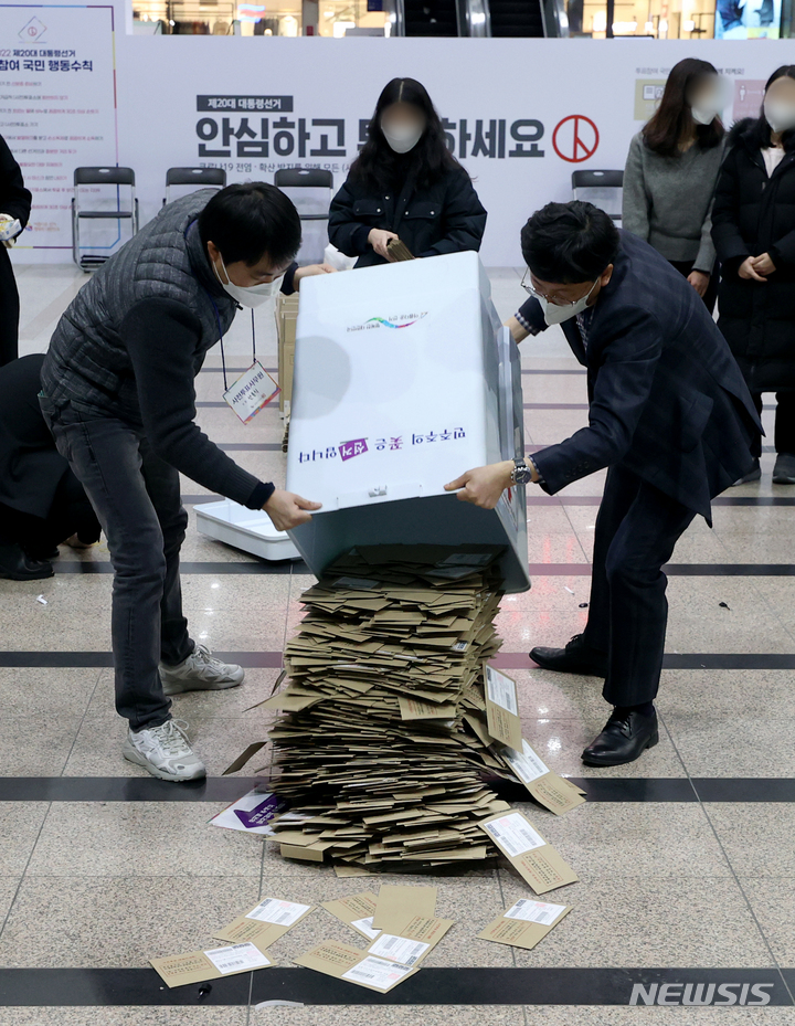 [서울=뉴시스] 김병문 기자 = 제20대 대통령 선거 사전투표가 끝난 5일 오후 서울역에 설치된 남영동 사전투표소에서 관계자들이 투표함을 열고 있다. 2022.03.05. dadazon@newsis.com