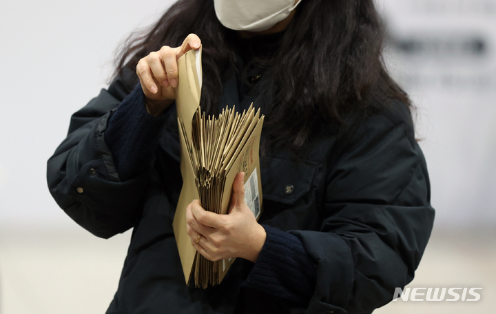 [서울=뉴시스] 김병문 기자 = 제20대 대통령 선거 사전투표가 끝난 지난 5일 오후 서울역에 설치된 남영동 사전투표소에서 관계자가 투표함을 열어 관외 투표용지 봉투를 확인하고 있다. 2022.03.05. dadazon@newsis.com