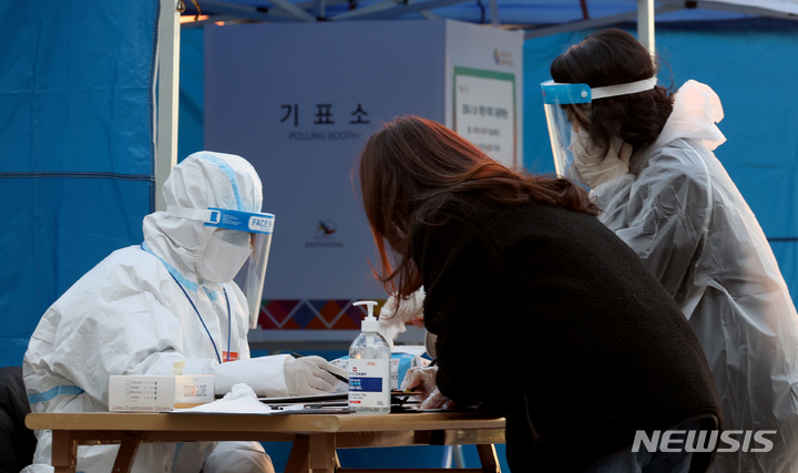 [서울=뉴시스] 김병문 기자 = 제20대 대통령선거 사전투표 이틀째인 5일 오후 서울역 설치된 남영동 사전투표소에서 코로나19 확진자 및 자가격리자들이 투표에 앞서 신원 확인을 하고 있다. 2022.03.05. dadazon@newsis.com