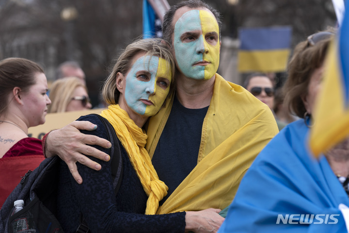 [워싱턴=AP/뉴시스] 6일(현지시간) 미 워싱턴 백악관 밖에서 러시아의 우크라이나 침공에 항의하는 집회가 열려 얼굴에 우크라이나 국기 색상으로 칠한 사람들이 참여하고 있다. 2022.03.07.