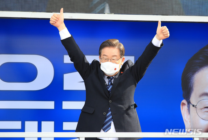 [제주=뉴시스] 우장호 기자 = 이재명 더불어민주당 대선후보가 7일 오전 제주시 동문시장에서 유세차량에 올라 연설을 마친 뒤 지지자와 유권자들에게 인사하고 있다. 이 후보는 대선을 이틀 앞둔 이날 제주를 시작으로 부산, 대구, 대전, 충북 유권자들을 차례로 만나면서 막바지 지지 호소에 나설 예정이다. 2022.03.07. woo1223@newsis.com