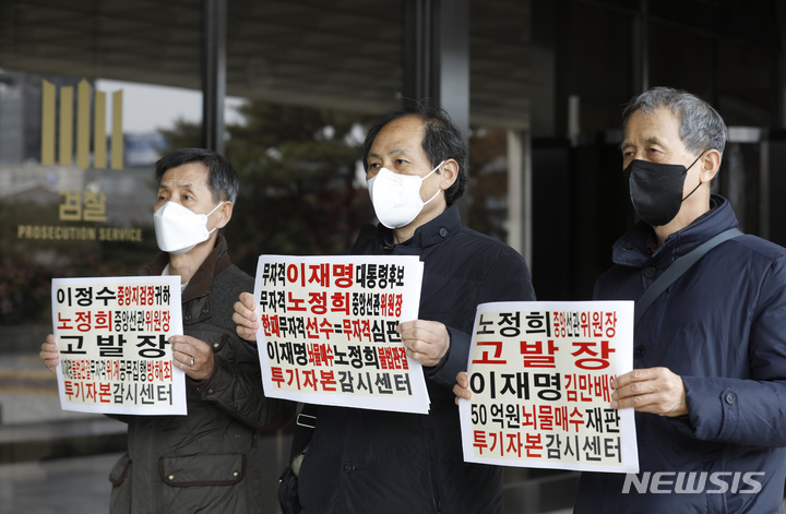 [서울=뉴시스] 고승민 기자 = '투기자본감시센터' 회원들이 7일 서울중앙지방검찰청에서 사전투표 관련 노정희 선관위원장에 대한 고발장을 접수하기 전 피켓을 들고 포즈를 취하고 있다. 2022.03.07. kkssmm99@newsis.com