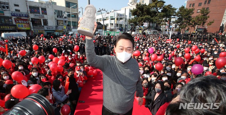 [제주=뉴시스] 전신 기자 = 윤석열 국민의힘 대선 후보가 지난 8일 제주 제주시 동문시장 인근에서 시민들을 향해 지지를 호소하고 있다. 2022.03.08. photo1006@newsis.com