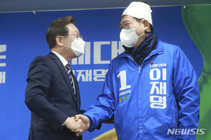 [서울=뉴시스] 최진석 기자 = 이재명 더불어민주당 대선후보가 8일 오전 서울 여의도 당사에서 '위기극복, 국민통합 특별 기자회견'에서 전일 선거운동 중 괴한에게 둔기 피습을 당한 송영길 대표의 손을 잡고 있다. (공동취재사진) 2022.03.08. photo@newsis.com