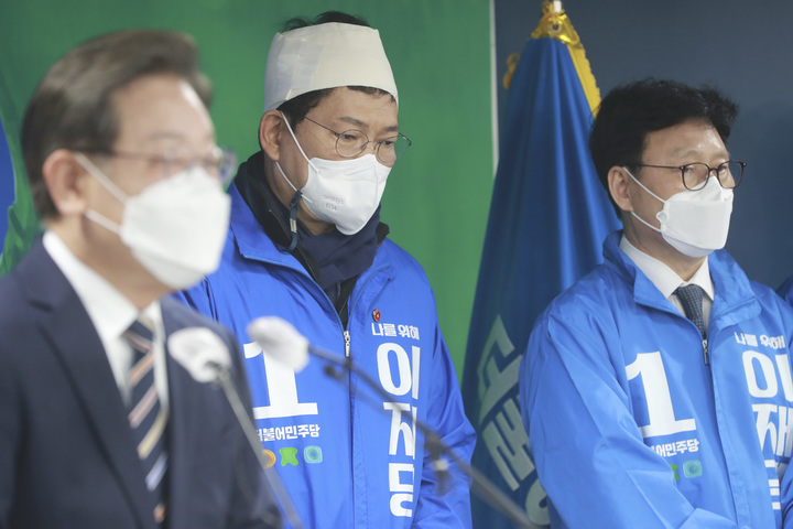 [서울=뉴시스] 최진석 기자 = 선거운동 중 괴한에게 둔기 피습을 당한 송영길 더불어민주당 대표가 8일 오전 서울 여의도 당사에서 열린 이재명 더불어민주당 대선후보의 '위기극복, 국민통합 특별 기자회견'에 붕대를 두르고 참석해 있다. (공동취재사진) 2022.03.08. photo@newsis.com