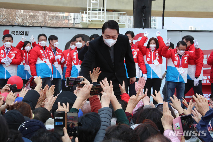 [부산=뉴시스] 전신 기자 = 윤석열 국민의힘 대선후보가 투표를 하루 앞둔 8일 부산 연제구에서 열린 "국민이 승리합니다" 부산 거점 유세에서 지지자들의 환호에 손을 잡아 인사하고 있다. 2022.03.08. photo1006@newsis.com