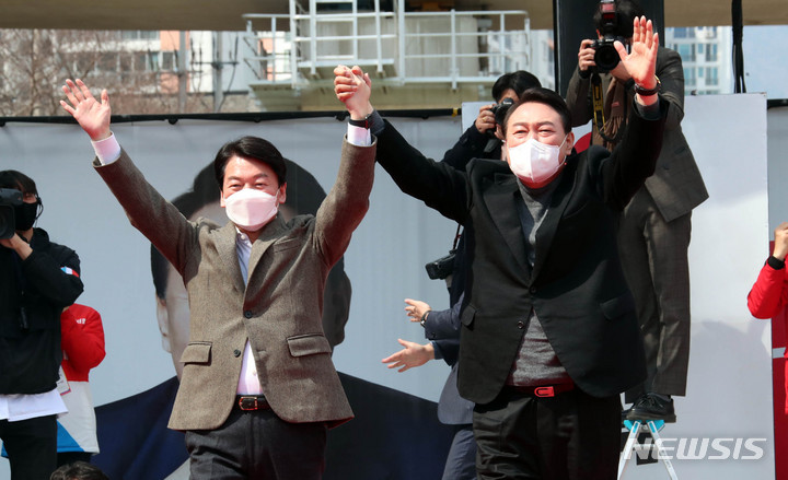 [부산=뉴시스] 전신 기자 = 윤석열 국민의힘 대선후보가 투표를 하루 앞둔 8일 부산 연제구에서 열린 "국민이 승리합니다" 부산 거점 유세에서 윤 후보 지지를 선언한 뒤 후보직을 사퇴한 국민의당 안철수 대표와 지지자들의 환호에 손을 들어 인사하고 있다. 2022.03.08. photo1006@newsis.com