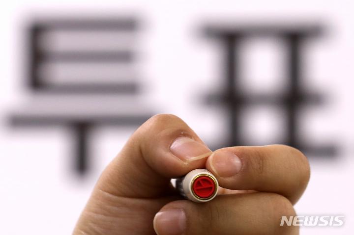 [서울=뉴시스] 조성우 기자 = 제20대 대통령선거를 하루 앞둔 8일 오후 서울 종로구 청운효자동 자치회관에서 종로구청 직원이 기표 도장을 들어 보이고 있다. 2022.03.08. xconfind@newsis.com