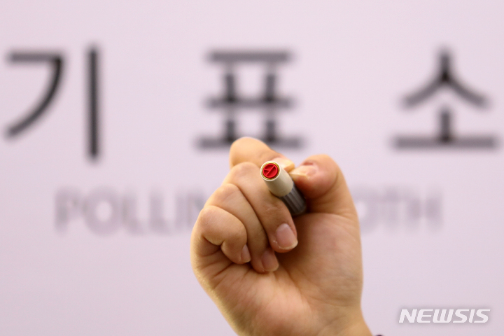 [서울=뉴시스] 조성우 기자 = 제20대 대통령선거를 하루 앞둔 8일 오후 서울 종로구 청운효자동 자치회관에서 종로구청 직원이 기표 도장을 들어 보이고 있다. 2022.03.08. xconfind@newsis.com