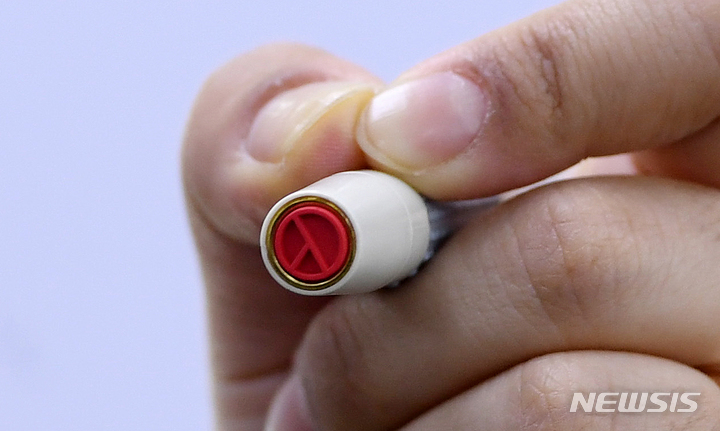 [서울=뉴시스] 조성우 기자 = 제20대 대통령선거를 하루 앞둔 8일 오후 서울 종로구 청운효자동 자치회관에 마련된 청운효자동 제3투표소에서 종로구청 직원이 기표 도장을 들어 보이고 있다. (공동취재사진) 2022.03.08. photo@newsis.com