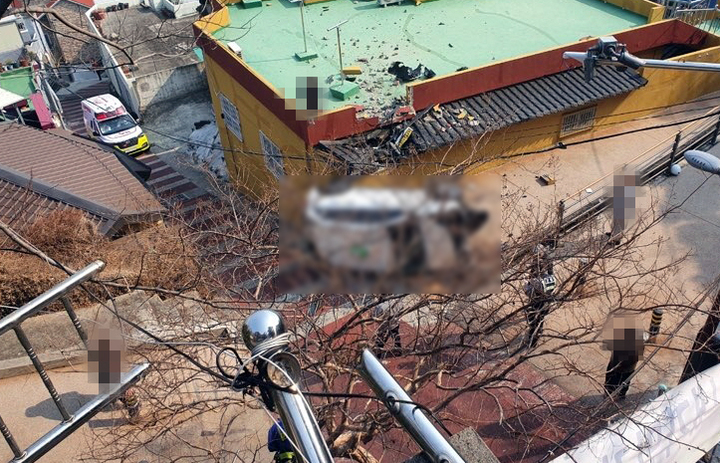 [부산=뉴시스] 부산 동구의 한 사찰 주차장에서 난간 뚫고 주택으로 추락한 택시. (사진=부산경찰청 제공) *재판매 및 DB 금지