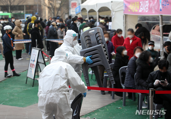 [서울=뉴시스] 조성우 기자 = 코로나19 신규 확진자가 34만 2,446명으로 역대 최다를 기록한 9일 오전 서울 송파구 보건소 선별진료소에서 의료진이 신속항원검사 결과 대기자를 위해 의자를 설치하고 있다. 2022.03.09. xconfind@newsis.com