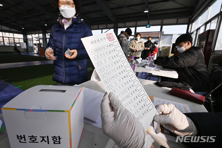 [수원=뉴시스] 김종택기자 = 제20대 대통령선거 투표일인 9일 경기도 수원시 세류동 게이트볼장에 마련된 세류2동 제4투표소에서 유권자들이 투표용지를 건네받고 있다. 2022.03.09. jtk@newsis.com