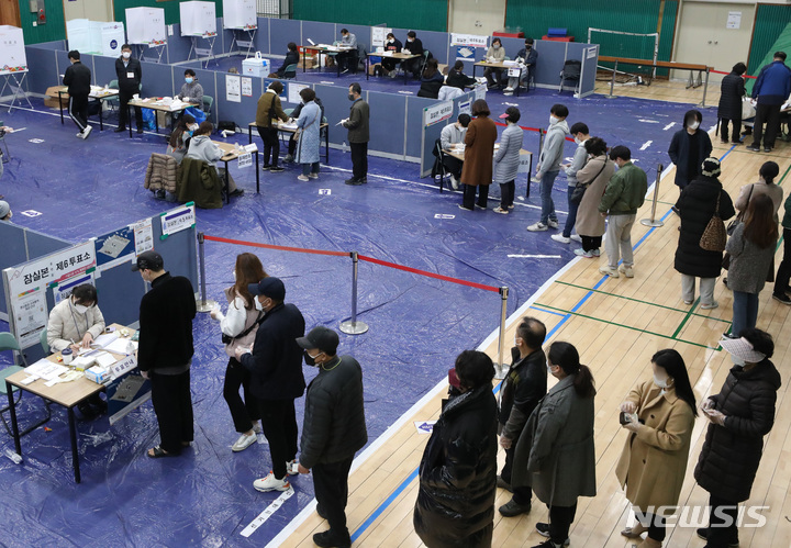 [서울=뉴시스] 조수정 기자 = 제20대 대통령선거 본투표일인 9일 서울 송파구 잠전초등학교 체육관에 마련된 잠실본동 제4·5·6 투표소에서 유권자들이 투표를 하기 위해 줄서 기다리고 있다. 2022.03.09. chocrystal@newsis.com