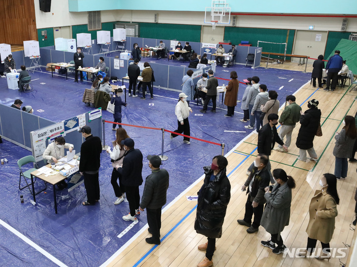 [서울=뉴시스] 조수정 기자 = 제20대 대통령선거 본투표일인 9일 서울 송파구 잠전초등학교 체육관에 마련된 잠실본동 제4·5·6 투표소에서 유권자들이 투표를 하기 위해 줄서 기다리고 있다. 2022.03.09. chocrystal@newsis.com