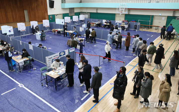 [서울=뉴시스] 조수정 기자 = 제20대 대통령선거 본투표일인 9일 서울 송파구 잠전초등학교 체육관에 마련된 잠실본동 제4·5·6 투표소에서 유권자들이 투표를 하기 위해 줄서 기다리고 있다. 2022.03.09. chocrystal@newsis.com