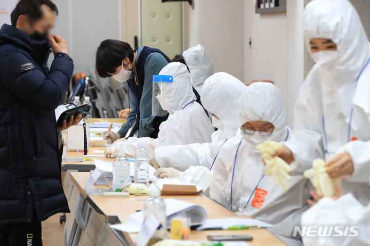 [제주=뉴시스] 우장호 기자 = 제20대 대통령선거일인 9일 오후 제주시 이도2동 제3투표소에서 사무원들이 코로나19 격리·확진자 투표를 위해 방호복을 착용하고 있다. 2022.03.09. woo1223@newsis.com