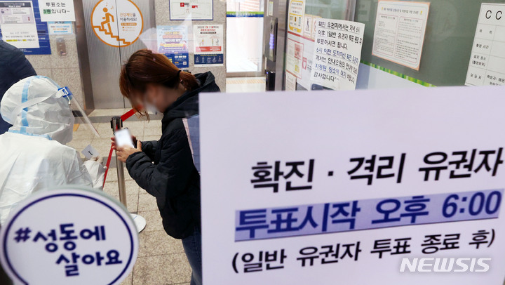 [서울=뉴시스] 홍효식 기자 = 제20대 대통령선거 투표일인 9일 오후 서울 성동구 성수1가 제2동 공공복합청사에 마련된 제1투표소에서 코로나19 확진자가 선거 사무원에게 문자를 보여주고 있다. 2022.03.09. yesphoto@newsis.com