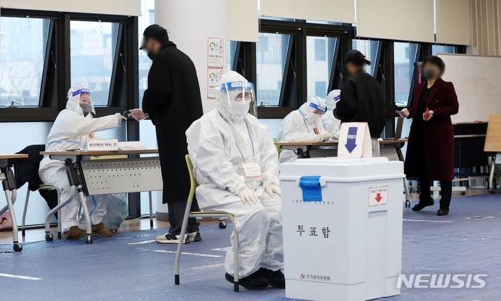 [서울=뉴시스] 홍효식 기자 = 제20대 대통령선거 투표일인 지난 3월9일 오후 서울 성동구 성수1가 제2동 공공복합청사에 마련된 제1투표소에서 코로나19 확진자들이 신분 확인을 하고 있다. 2022.03.09. yesphoto@newsis.com
