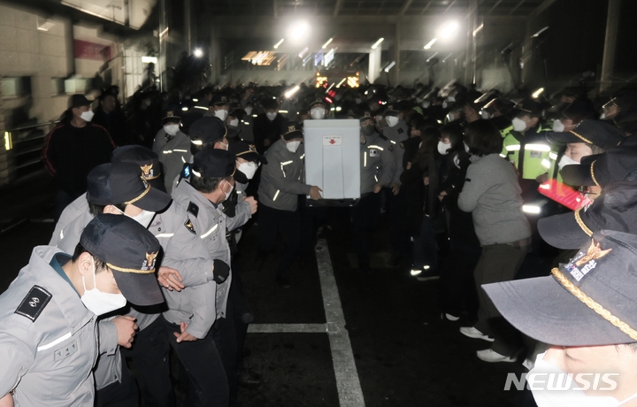 [인천=뉴시스] 김동영 기자 = 제20대 대통령 선거 투표가 종료된 10일 새벽 인천 부평구 삼산월드체육관 주차장에서 경찰이 유튜브 채널 '가로세로연구소(가세연)'측 및 일부 인천시민들과 투표함 이송을 두고 대치하던 중 강제로 투표함을 빼앗아 개표소로 가지고 가고있다. 2022.03.10. dy1021@newsis.com 