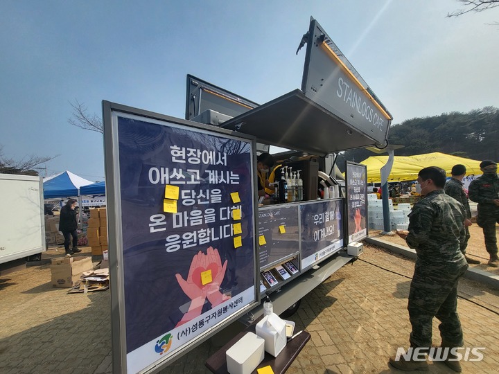 [울진=뉴시스] 이바름 기자 = 지난 4일 경북 울진에서 발생한 산불이 7일째 꺼지지 않는 가운데 산불진화현장에 투입된 해병대원이 점심식사 후 (사)성동구자원본사센터에서 마련한 커피차에서 음료를 기다리고 있다. 2022.03.10. right@newsis.com