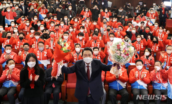 [서울=뉴시스] 전신 기자 = 윤석열 제20대 대통령 당선인이 10일 새벽 서울 여의도 국회도서관에 마련된 국민의힘 제20대 대통령선거 개표상황실에서 꽃다발을 들고 있다. (공동취재사진) 2022.03.10. photo@newsis.com