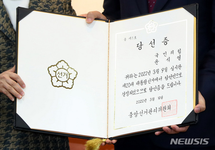 [과천=뉴시스] 추상철 기자 = 노정희 중앙선거관리위원장이 10일 오전 경기 과천시 중앙선거관리위원회에서 윤석열 당선인의 대리인 서일준 의원에게 당선증을 전달하고 있다. 2022.03.10. scchoo@newsis.com