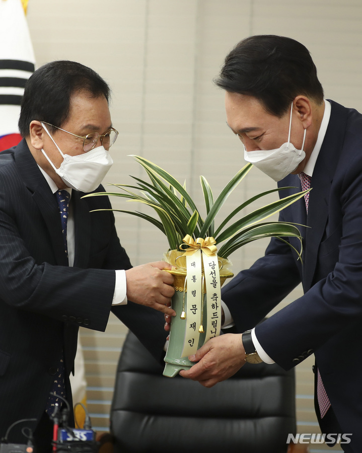 [서울=뉴시스] 최진석 기자 = 윤석열 대통령 당선인이 10일 오후 서울 여의도 국민의힘 당사에서 유영민 대통령 비서실장에게 문재인 대통령의 축하난을 받고 있다. 2022.03.10. myjs@newsis.com