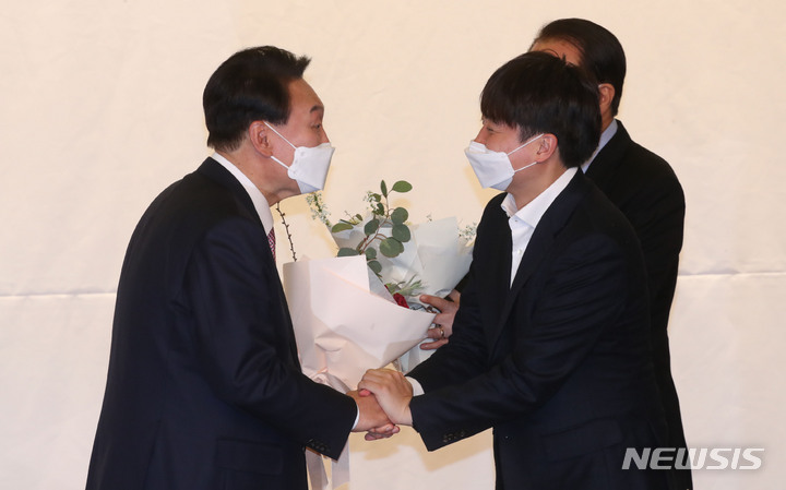 [서울=뉴시스] 최진석 기자 = 윤석열 대통령 당선인이 10일 서울 여의도 국회 도서관에서 열린 국민의힘 선대위 해단식에 참석해 이준석 당대표가 주는 축하 꽃다발을 받고 있다. (공동취재사진) 2022.03.10. photo@newsis.com