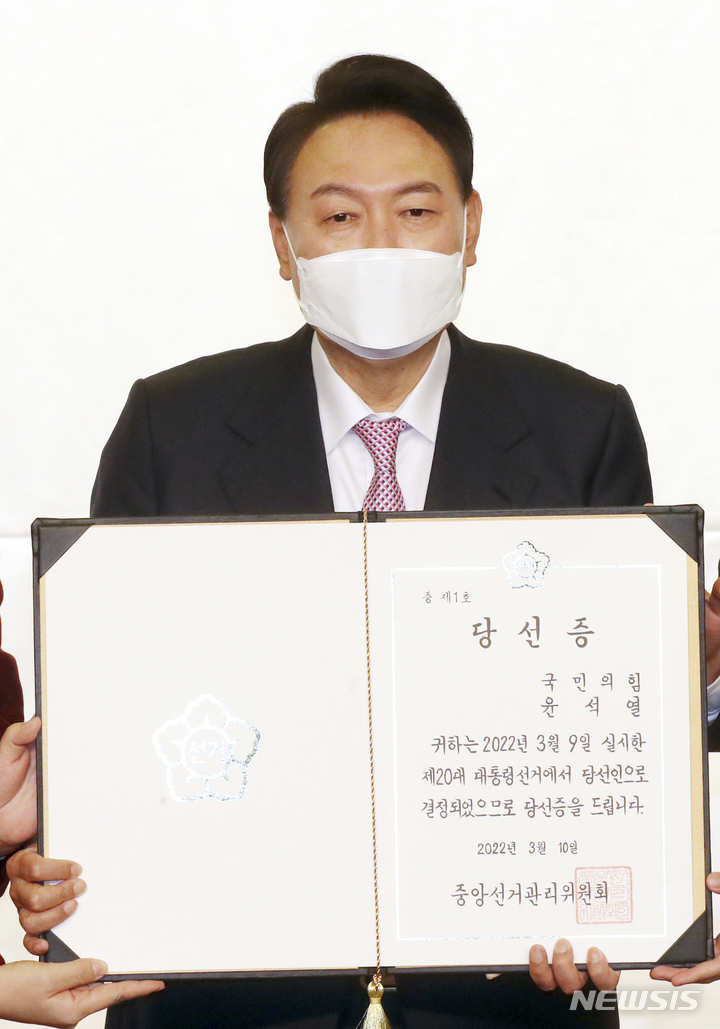 [서울=뉴시스] 최진석 기자 = 윤석열 대통령 당선인이 10일 서울 여의도 국회 도서관에서 열린 국민의힘 선대위 해단식에 참석해 당선증을 들어보이고 있다. (공동취재사진) 2022.03.10. photo@newsis.com