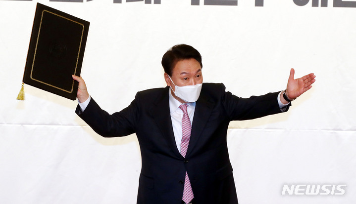 [서울=뉴시스] 최진석 기자 = 윤석열 대통령 당선인이 10일 서울 여의도 국회 도서관에서 열린 국민의힘 선대위 해단식에 참석해 당선증을 들어보이고 있다. (공동취재사진) 2022.03.10. photo@newsis.com