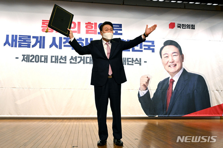 [서울=뉴시스] 최진석 기자 = 윤석열 대통령 당선인이 10일 오후 서울 여의도 국회도서관 대강당에서 열린 국민의힘 선대본부 해단식에서 당선증을 들어보이고 있다. (공동취재사진) 2022.03.10. photo@newsis.com