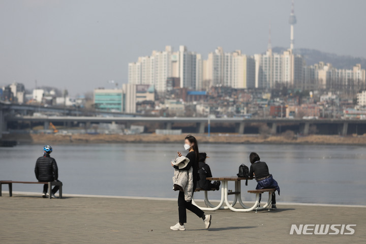 [서울=뉴시스] 권창회 기자 = 낮 최고기온이 20도 까지 오르는 등 따뜻한 봄 날씨를 보인 11일 오후 서울 서초구 반포한강공원에서 시민이 겉옷을 들고 이동하고 있다. 2022.03.11. kch0523@newsis.com