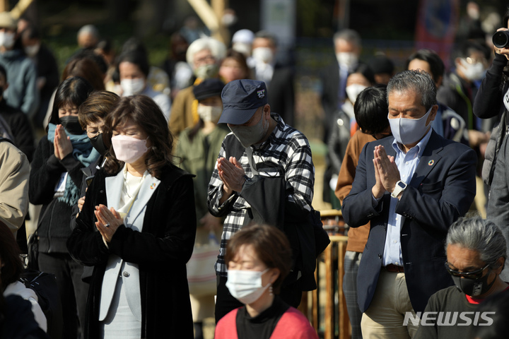 [도쿄=AP/뉴시스] 일본 도쿄 시내에서 11일 동일본 대지진 희생자를 추모하는 사이렌이 울리자 지나던 시민들이 멈춰서서 합장하며 명복을 빌고 있다.2022.03.15 