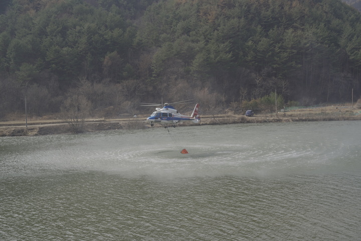 [울진=뉴시스] 이바름 기자 = 경북 울진 산불이 9일째 꺼지지 않는 가운데 산불 진압을 위해 투입된 소방헬기가 덕구저수지에서 취수하고 있다.(사진=경북소방본부 제공) 2022.03.12. photo@newsis.com *재판매 및 DB 금지