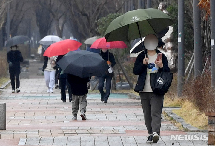 [광주=뉴시스] 변재훈 기자 = 서해안을 중심으로 봄비가 내리는 13일 오후 광주 서구 치평동 도심 공원에서 시민들이 우산을 쓴 채 걷고 있다. 2022.03.13. wisdom21@newsis.com