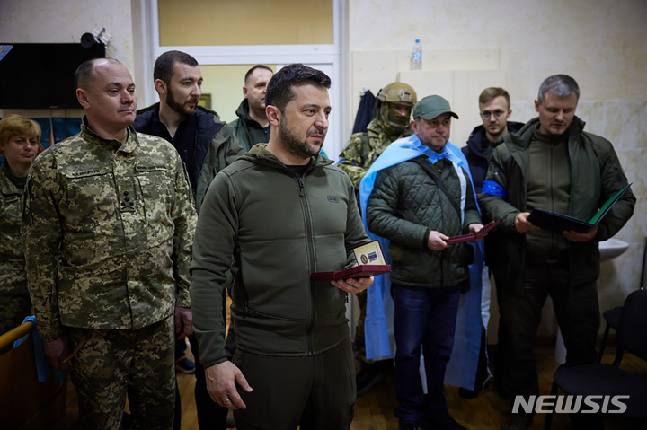 [키이우=AP/뉴시스] 볼로디미르 젤렌스키 우크라이나 대통령이 13일(현지시간) 키이우의 한 병원을 방문해 부상병에 훈장을 수여하고 있다. 2022.03.14.