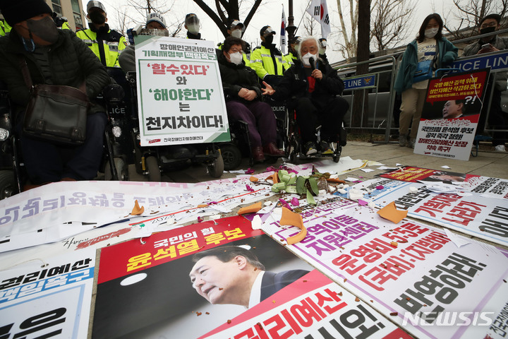 [서울=뉴시스] 조수정 기자 = 전국장애인차별철폐연대가 14일 오전 윤석열 대통령 당선인 인수위원회가 꾸려진 서울 종로구 통의동 금융감독원 연수원 인근에서 인수위 장애인 권리예산 반영 촉구 기자회견을 하며 인수위에 전달하려했던 축하 화분을 던져 부수고 있다. 이 기자회견은 인수위와 경찰 등의 불허로 인수위 앞에서 열리지 못하고 인수위 100미터 전방에서 열렸다. 2022.03.14. chocrystal@newsis.com