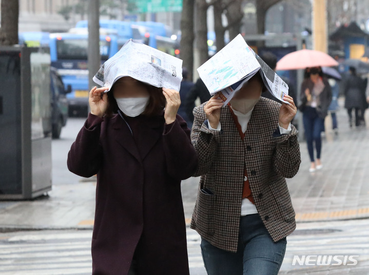 [서울=뉴시스] 조수정 기자 = 지난달 14일 오후 서울 중구 을지로에서 미처 우산을 준비하지 못한 시민들이 신문을 머리에 쓰고 걸어가고 있다. 2022.03.14. chocrystal@newsis.com