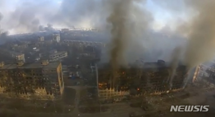 [마리우폴=AP/뉴시스] 우크라이나군 아조프 대대가 제공한 비디오 영상 사진에 지난 14일(현지시간) 우크라이나 마리우폴의 고층 건물들이 러시아군의 포격으로 불에 타 연기가 피어오르고 있다. 우크라이나 아조프해 인근 마리우폴은 러시아군에 포위돼 집중 포격을 받고 있다. 2022.03.15.
